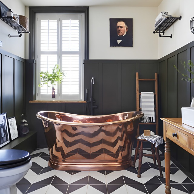 Copper bath freestanding in monochrome bathroom with wall panelling