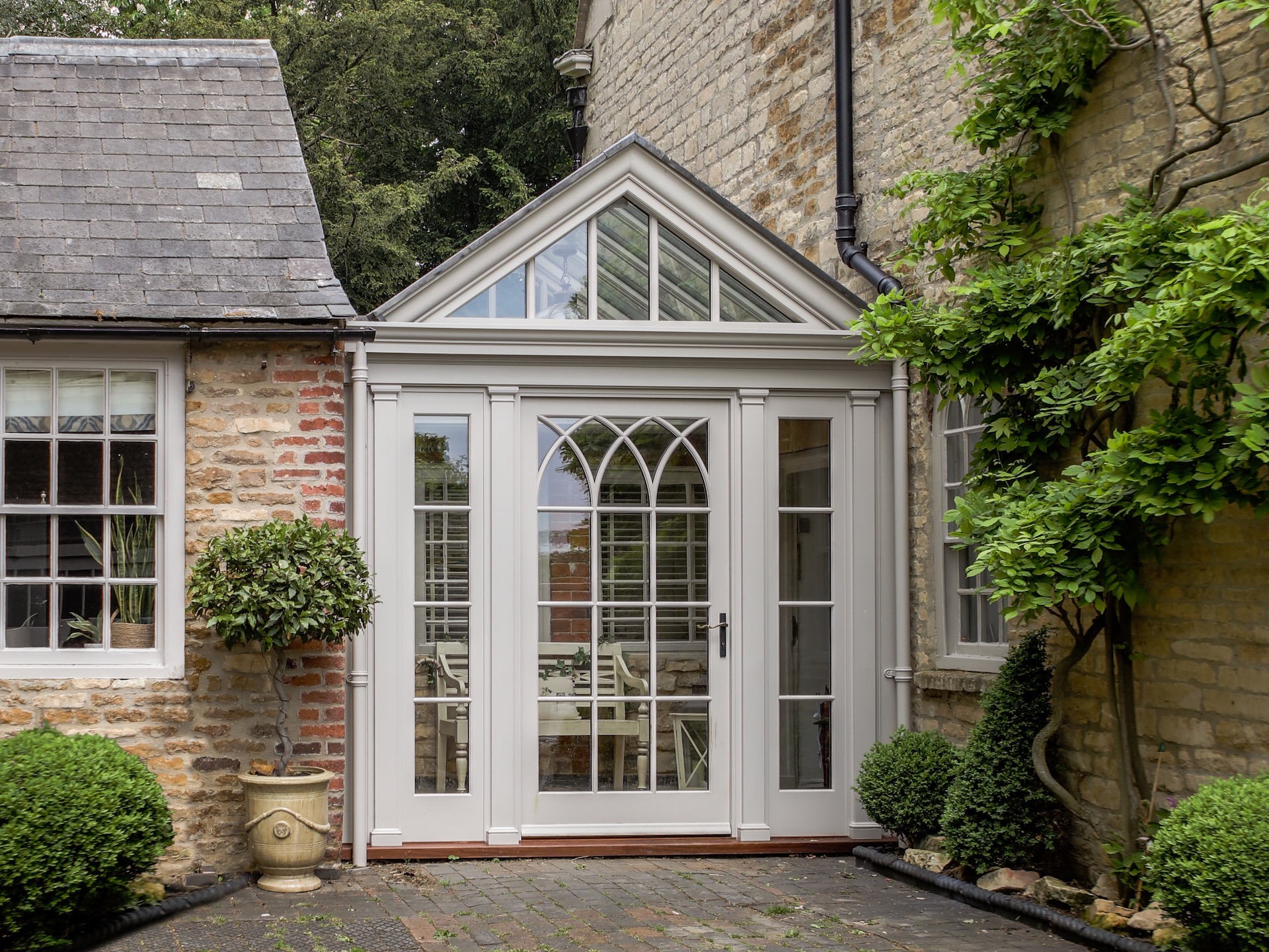 Mini glass orangery extension connecting two buildings