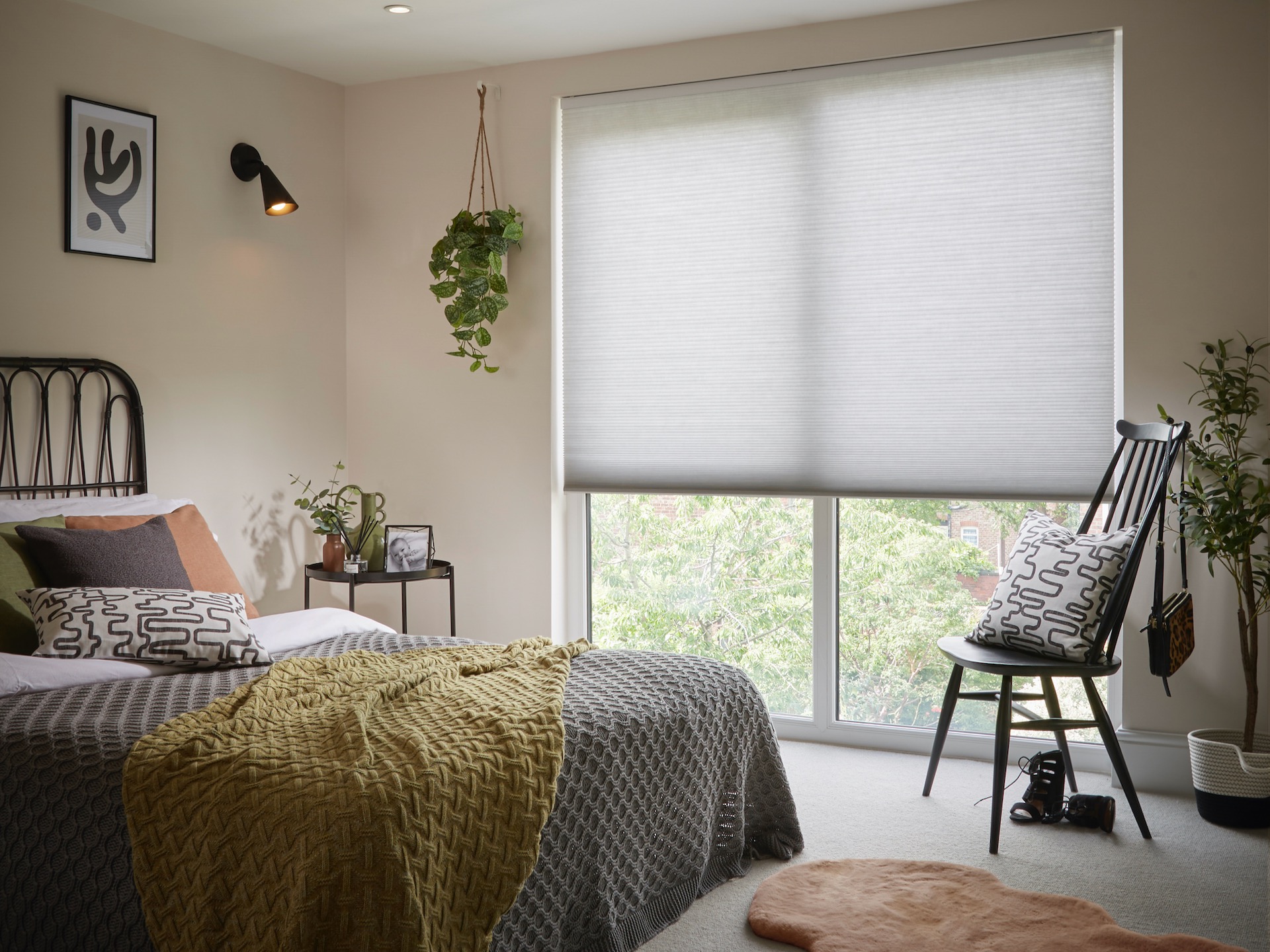 Grey pleated blinds in neutral bedroom