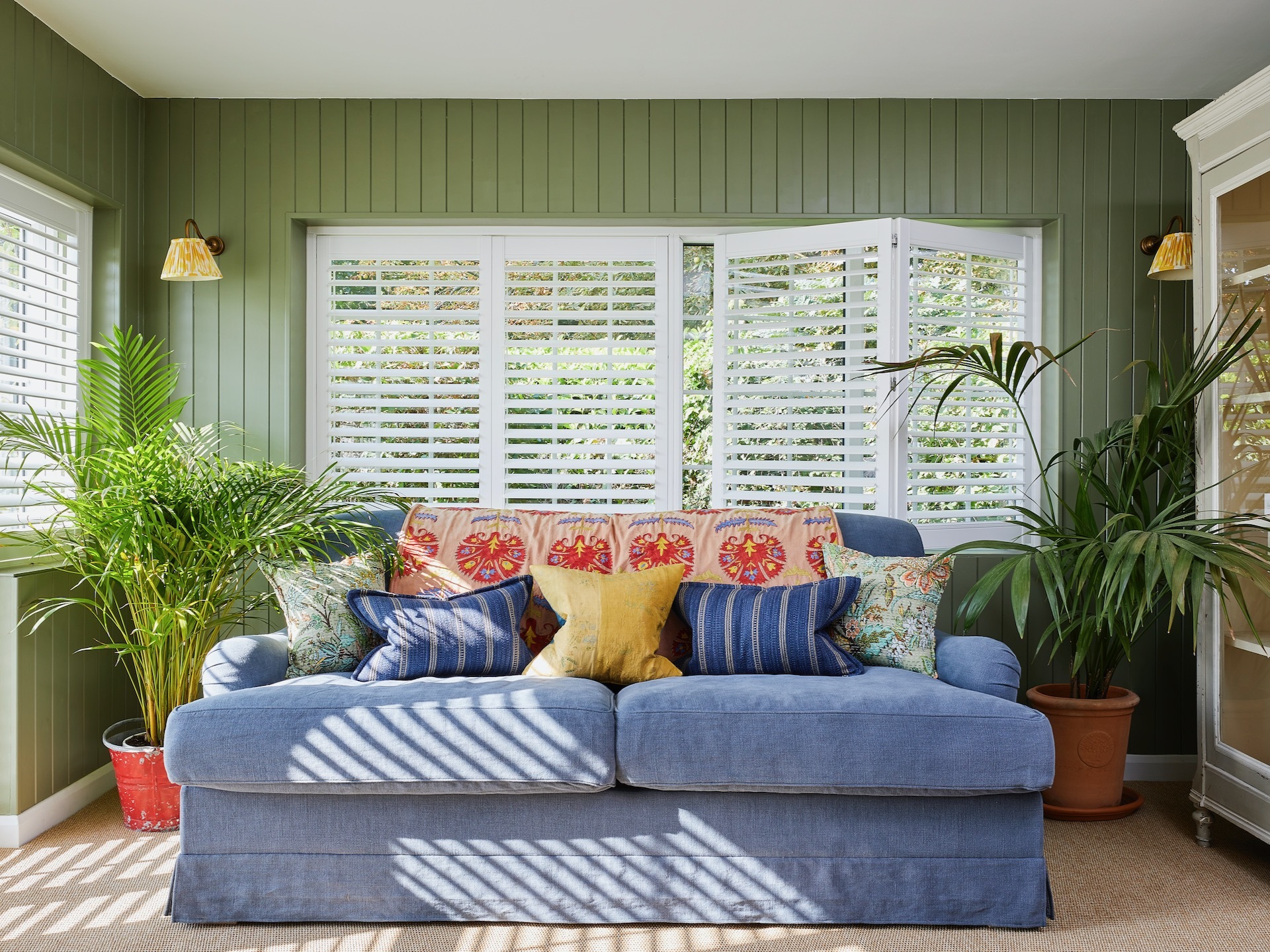 Waterbury vinyl shutters in Cotton White by Thomas Sanderson in green-clad dining room