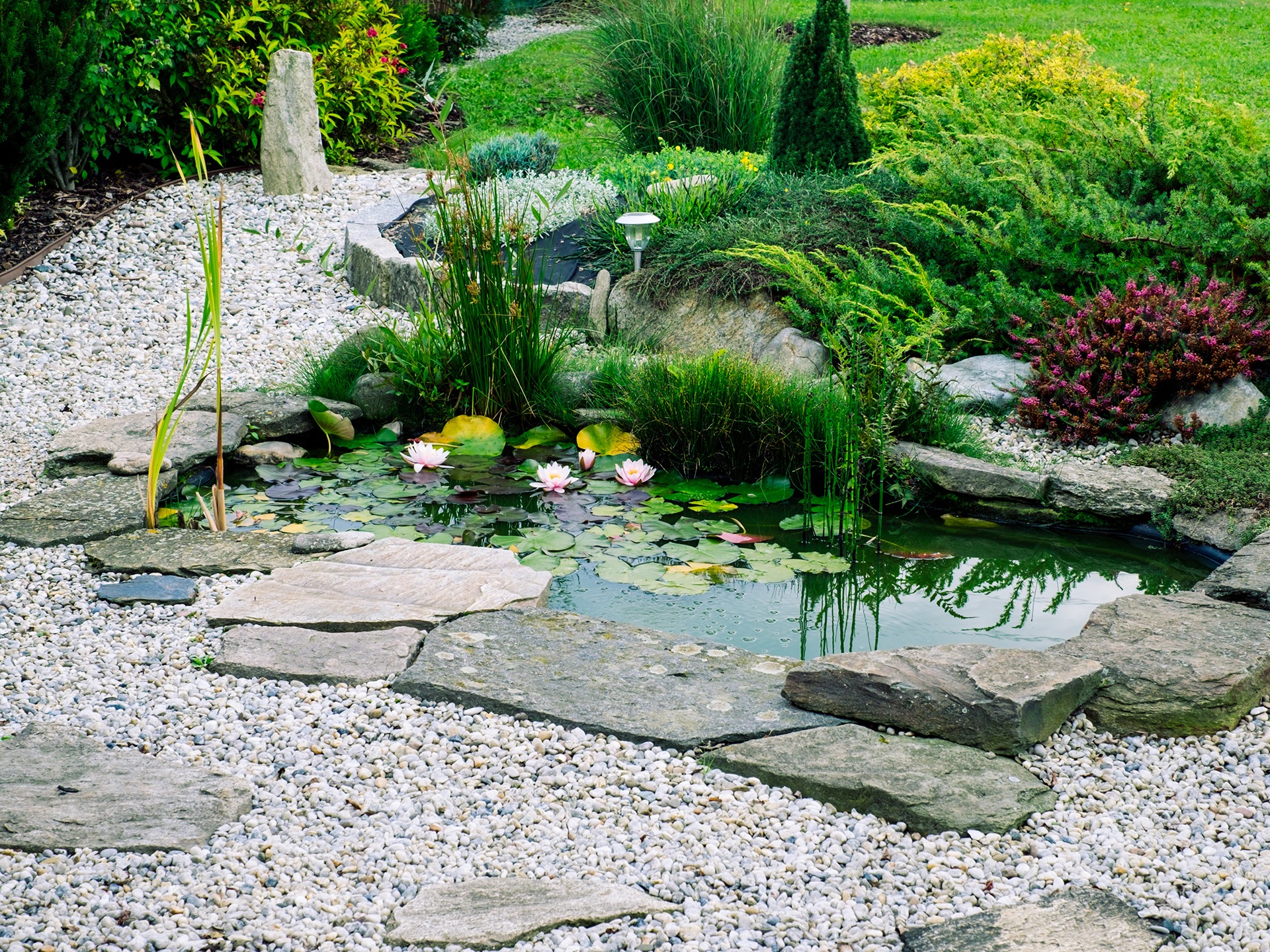 a garden with paving slabs and cobbel stones