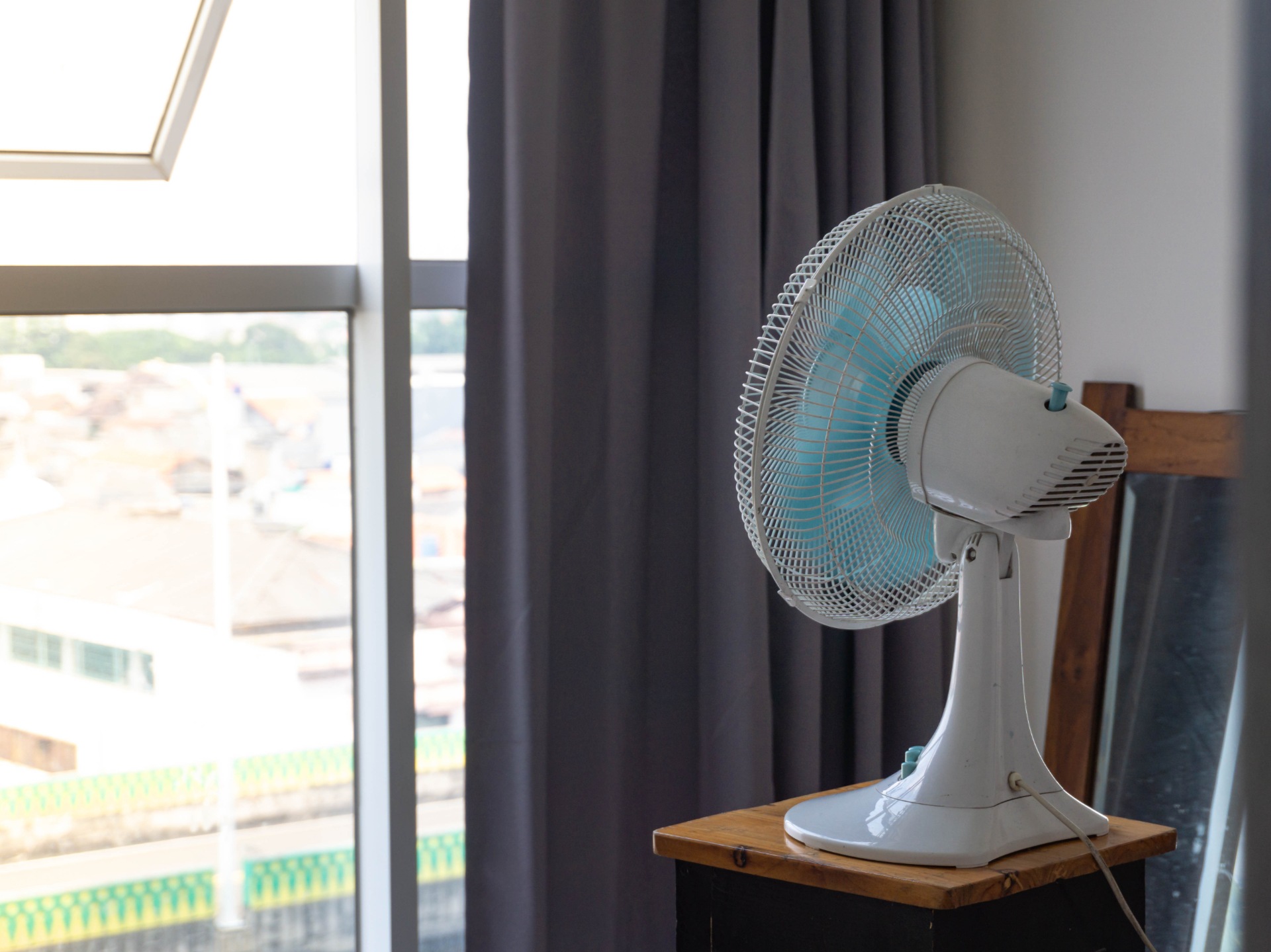 A fan pointing out of a window