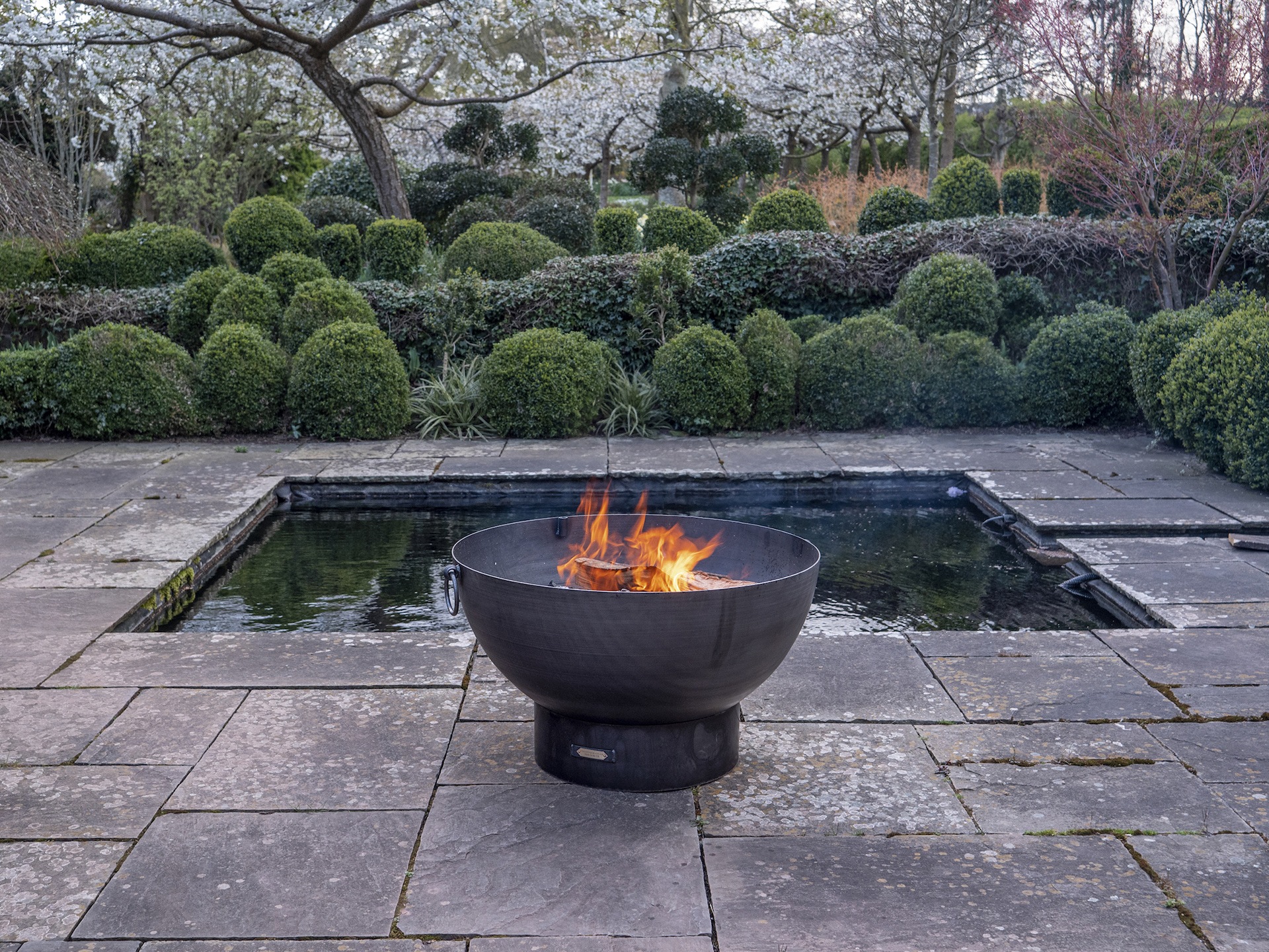 Firepit in front of a traditional square pond