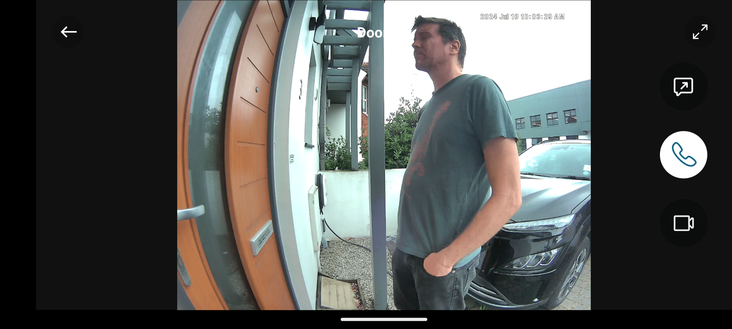 A still from smart doorbell footage showing a visitor waiting after pressing the bell button.