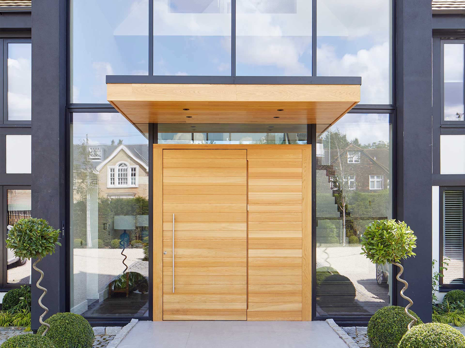 If you don't have the space for a full porch, you could enjoy the benefits of a door canopy.Clear windows with wooden door 