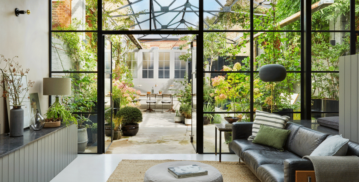 Looking through the living room to the outdoor courtyard of a converted Victorian dairy