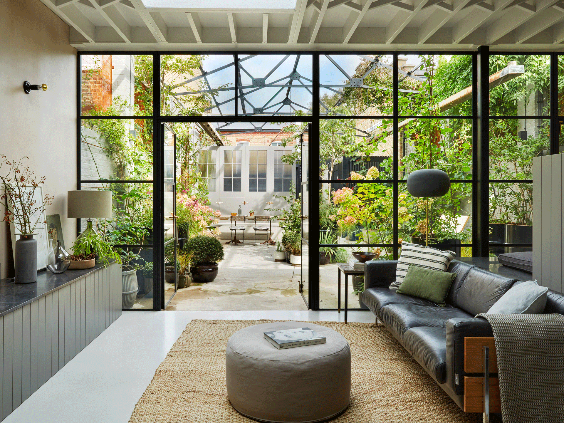 Looking through the living room to the outdoor courtyard of a converted Victorian dairy