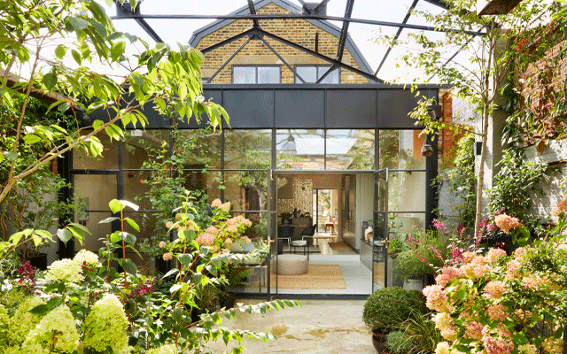 Looking from the courtyard garden to the living room of a converted Victorian Dairy reusing building materials