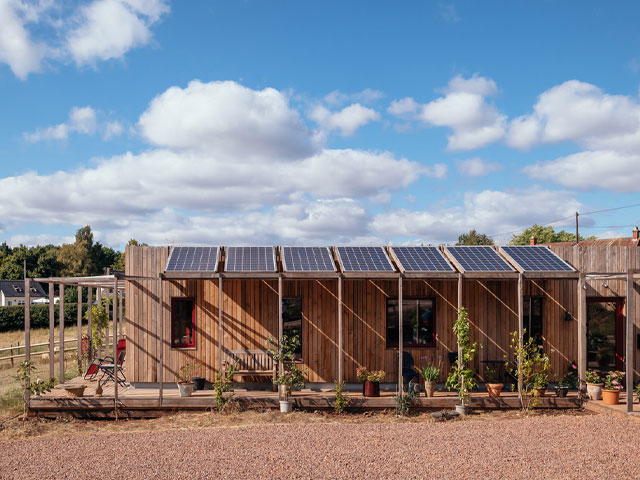 Side view of a timber house with a veranda covered in solar photovoltaic panels