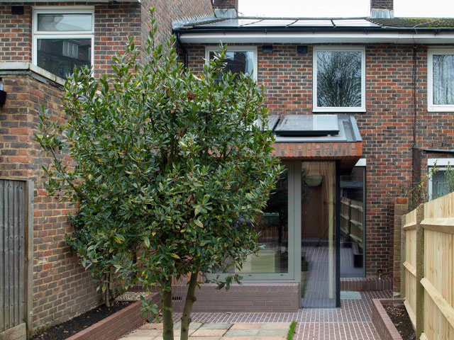 The rear of a terraced house with solar panels on two roof levels