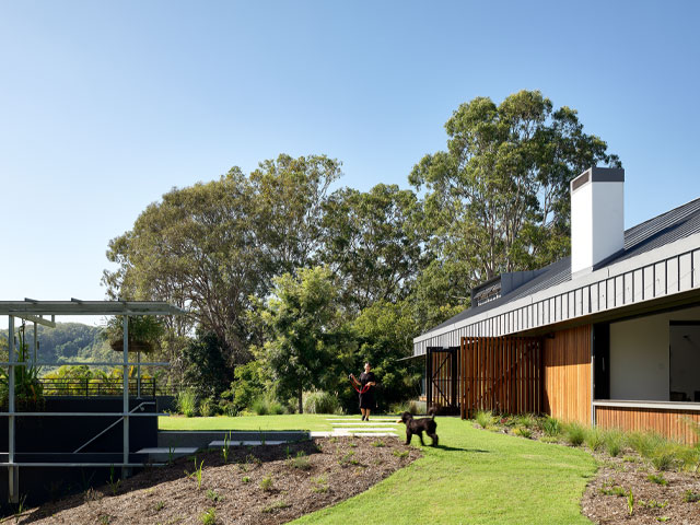 Back garden of house with adjacent walkway that has a roof incorporating solar panels