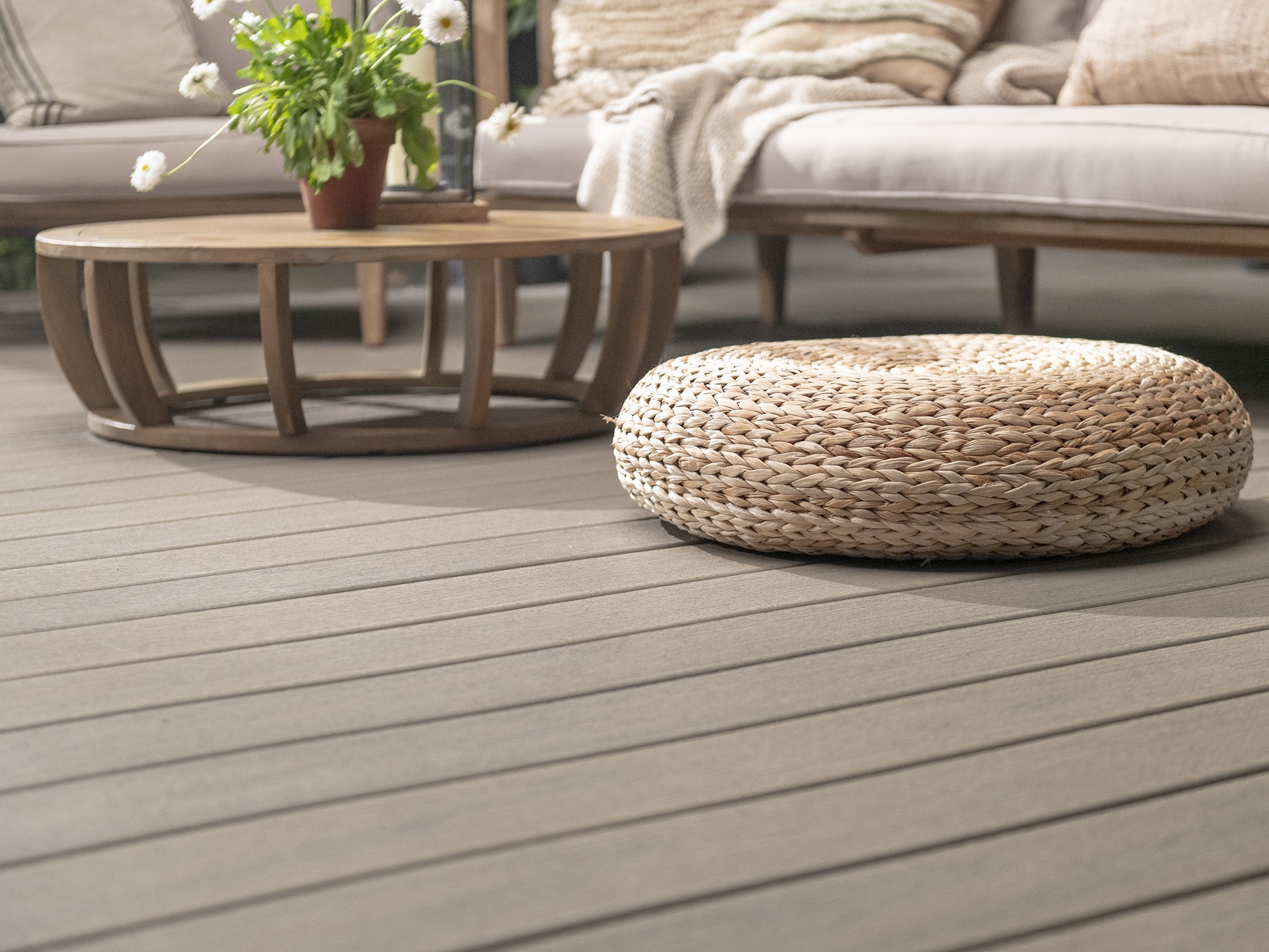 A coffee table, pouffe and sofa on a deck