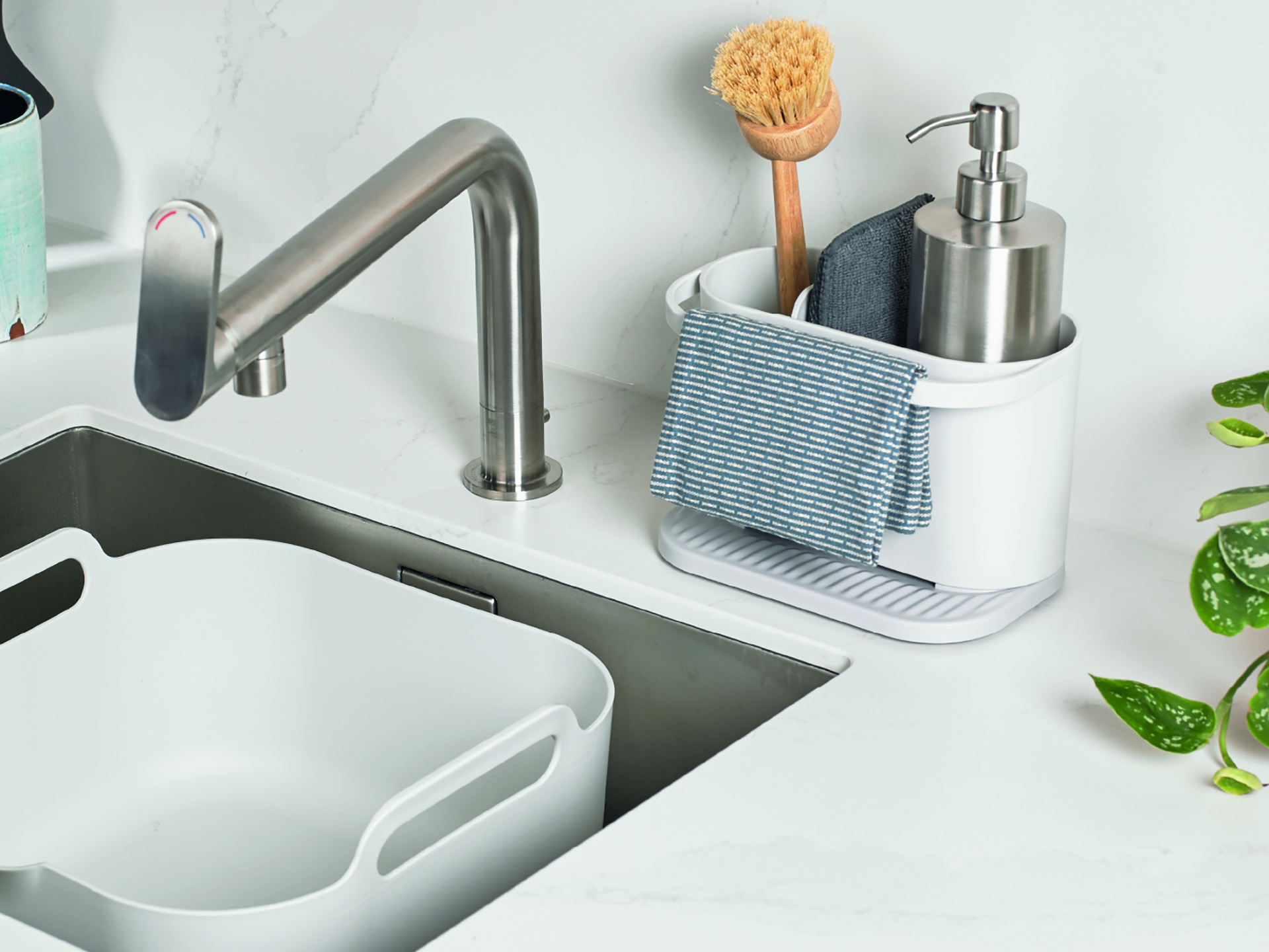 A sink with a sink caddy and washing-up bowl