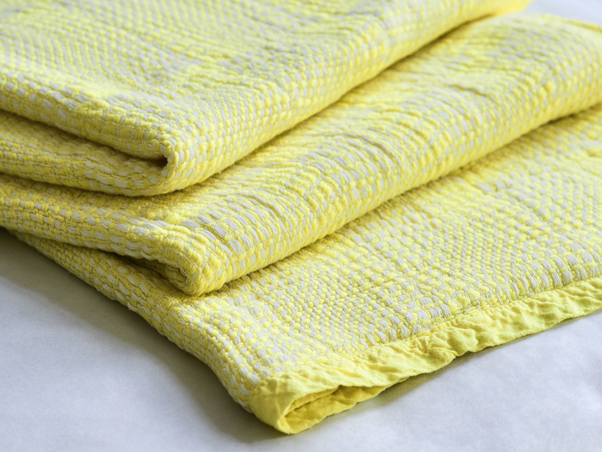 A close-up shot of a folded yellow throw 